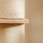 Close-up of natural birch wooden shelf attached to thick sisal-wrapped scratching post on cat tree tower