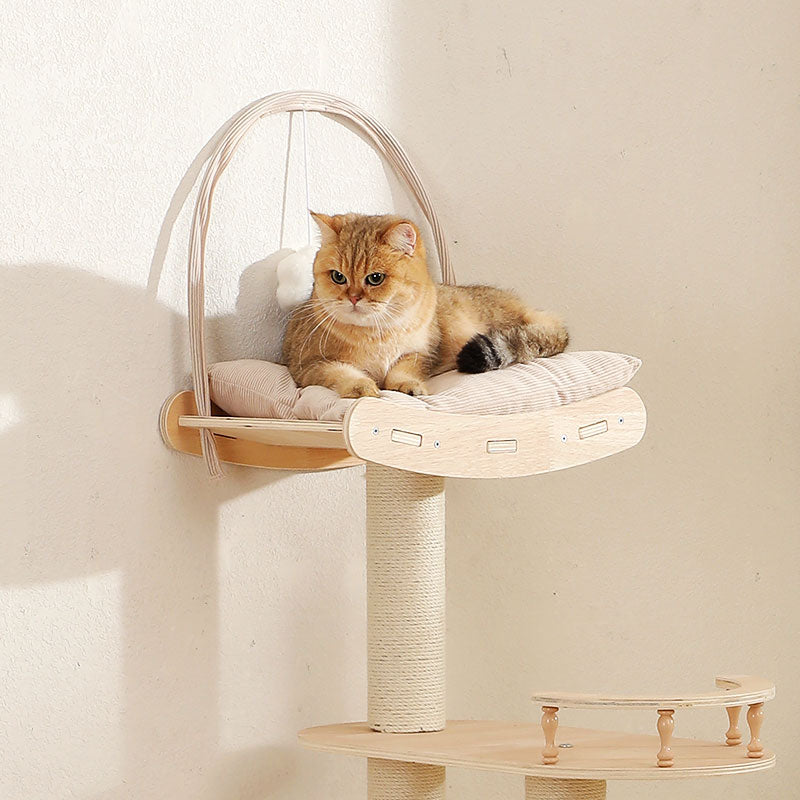 Golden cat with round eyes reclining on a cushioned wooden platform mounted to a sisal-wrapped post by a beige wall