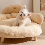 Beige bouclé XL pet couch bed with curved backrest and wooden legs, styled as a plush cat tower and scratcher, suitable for.
