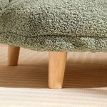 Close-up of wooden leg and textured green bouclé fabric on an XL pet couch bed for cats and dogs